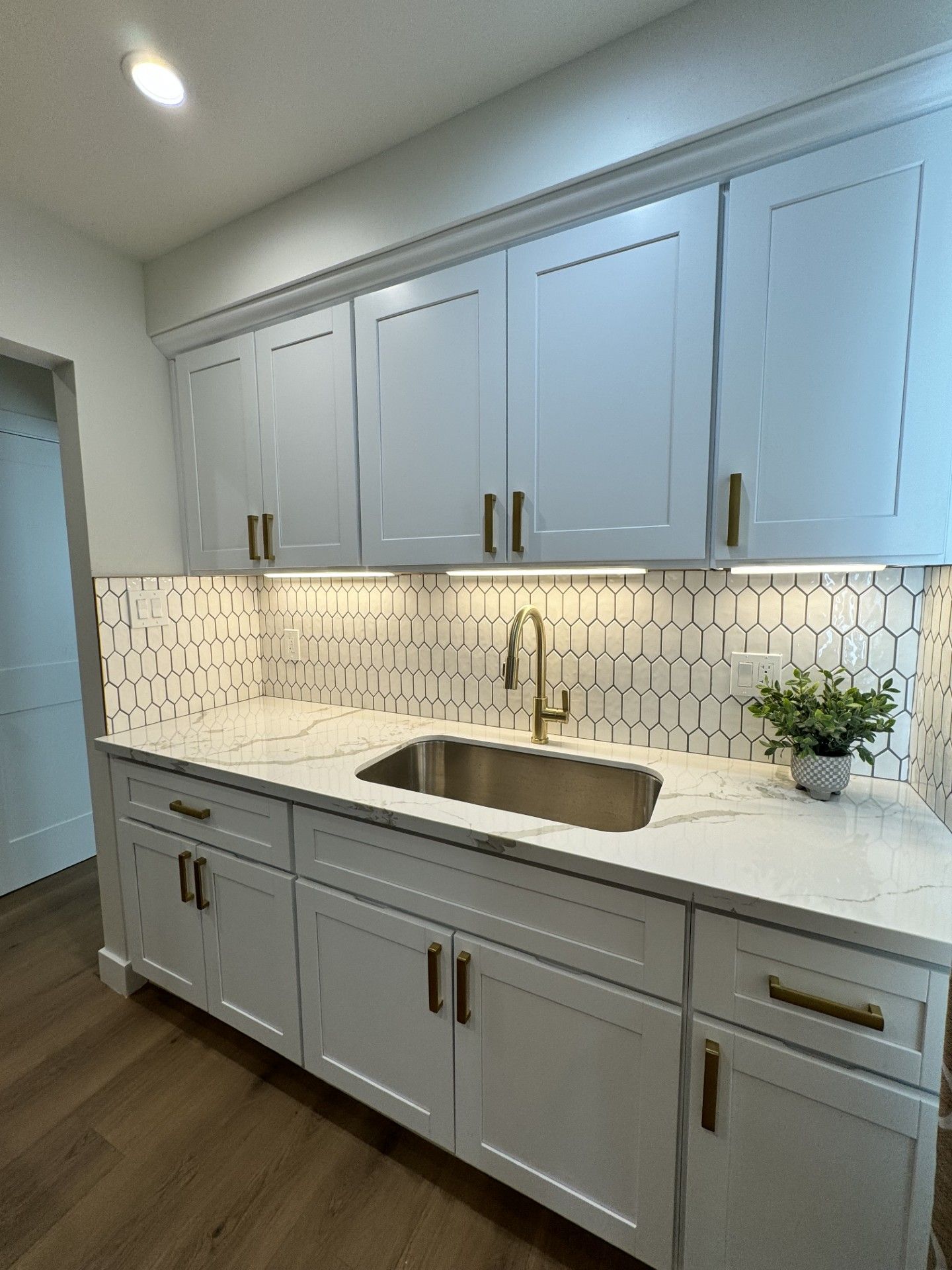 Kitchen remodel with gray cabinets and under-cabinet lighting