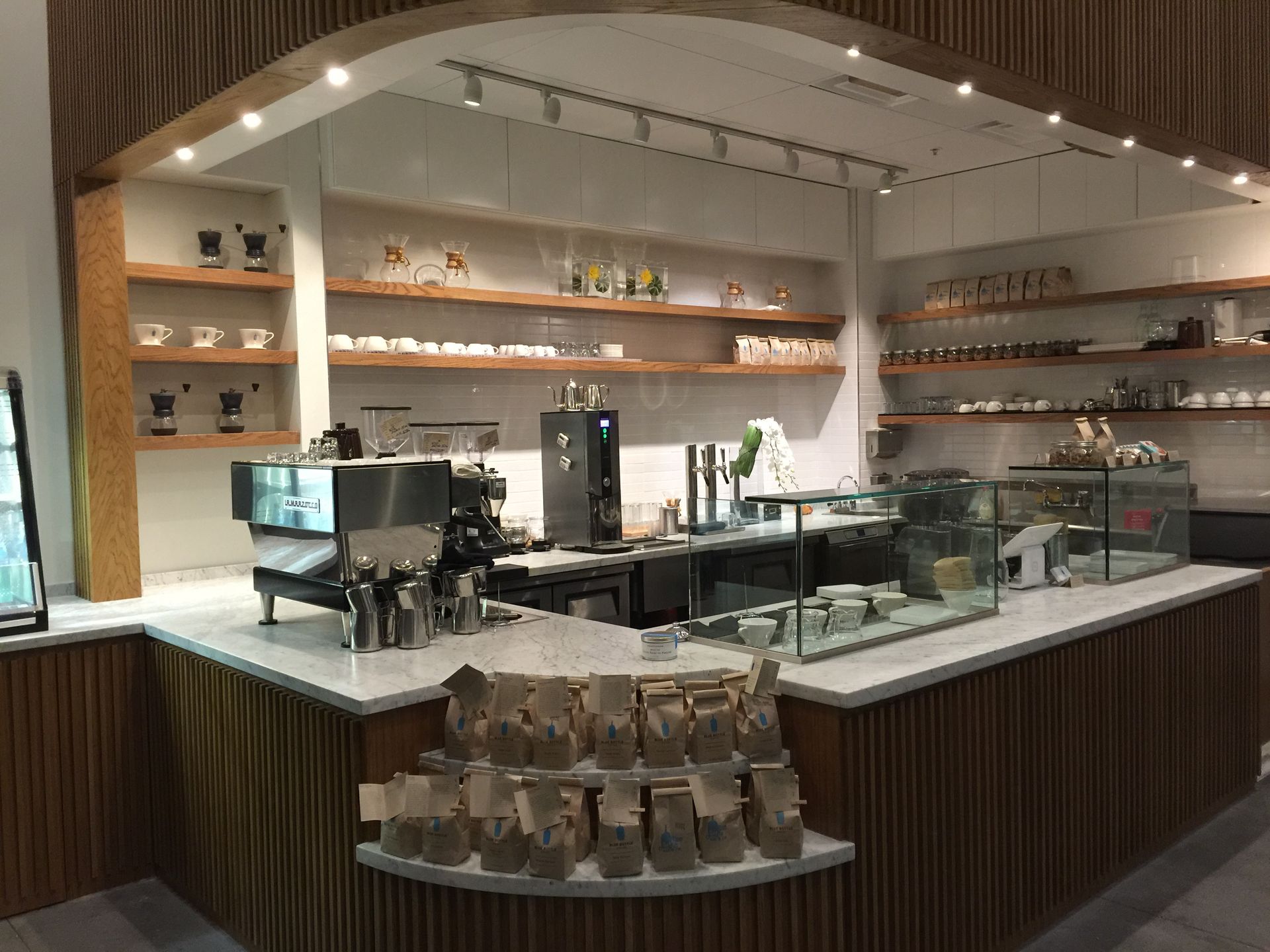 The inside of a restaurant with a counter and shelves.