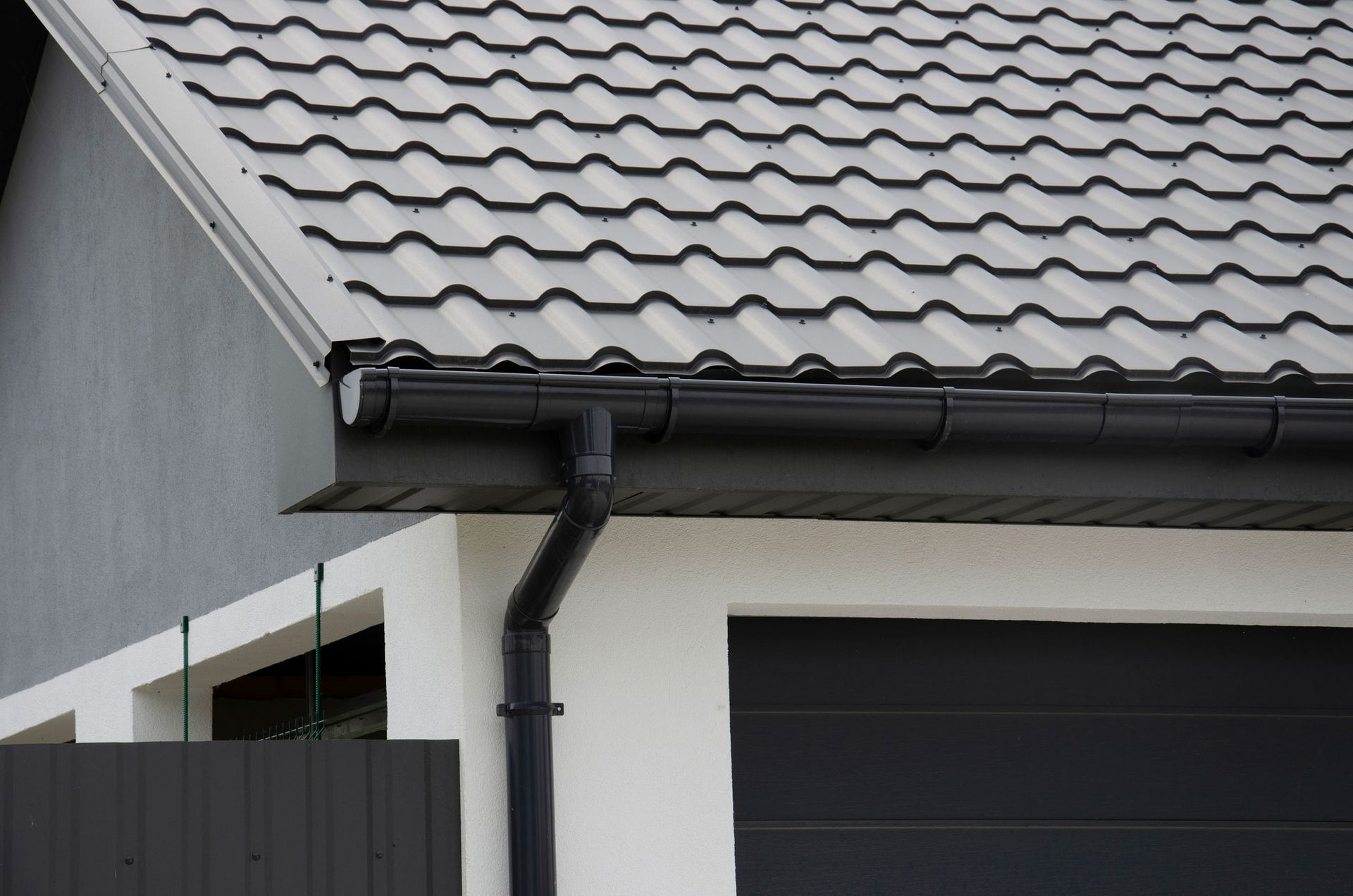 A close up of a gutter on the side of a house.