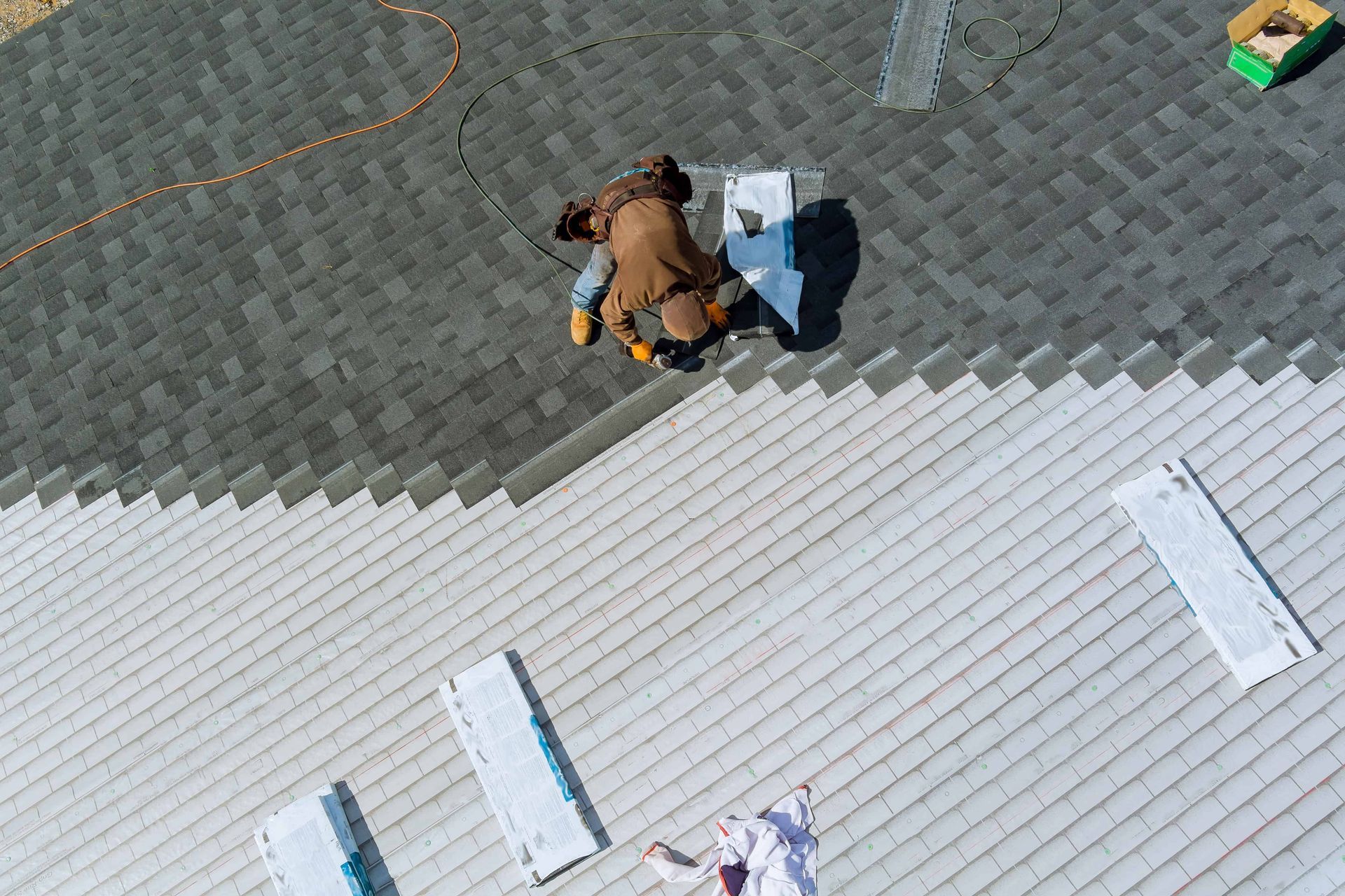 Person kneeling beside a blue-and-white object on a gray paved surface