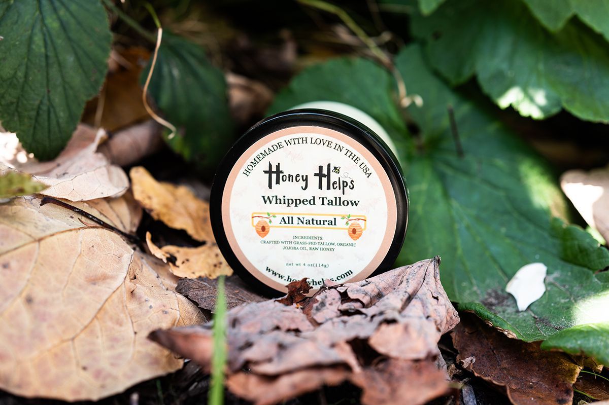 Whip Whip lip balm tin on fallen leaves and green foliage outdoors