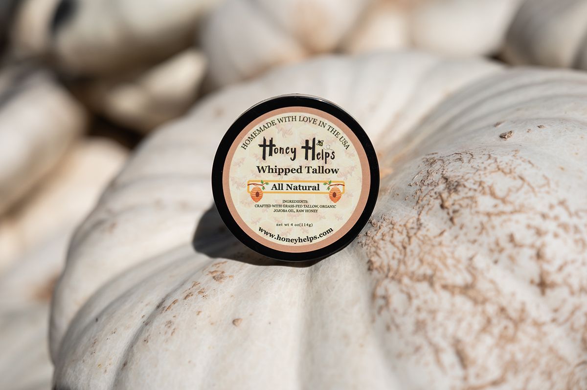 Honey Helps All Natural Whipped Tallow tin resting on a white pumpkin outdoors