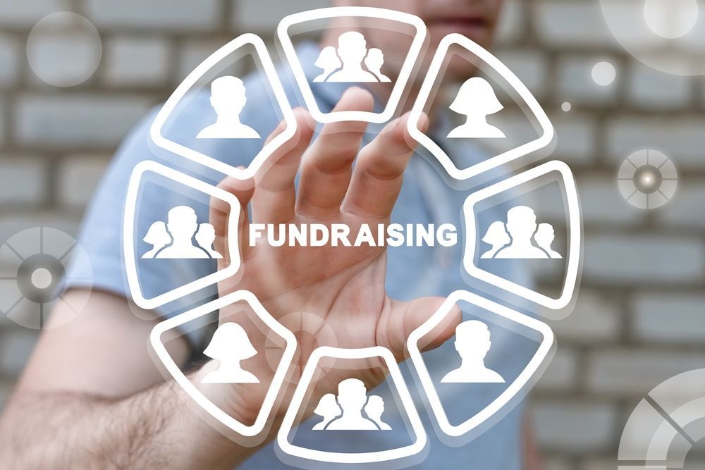 Person reaching for a fundraising concept with icons of people in a circle.