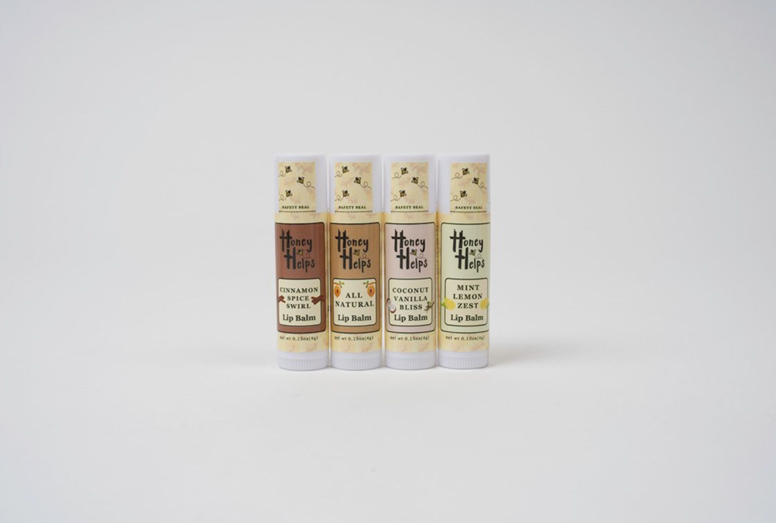Four Honey Helps lip balm tubes in assorted flavors displayed on a clean white background