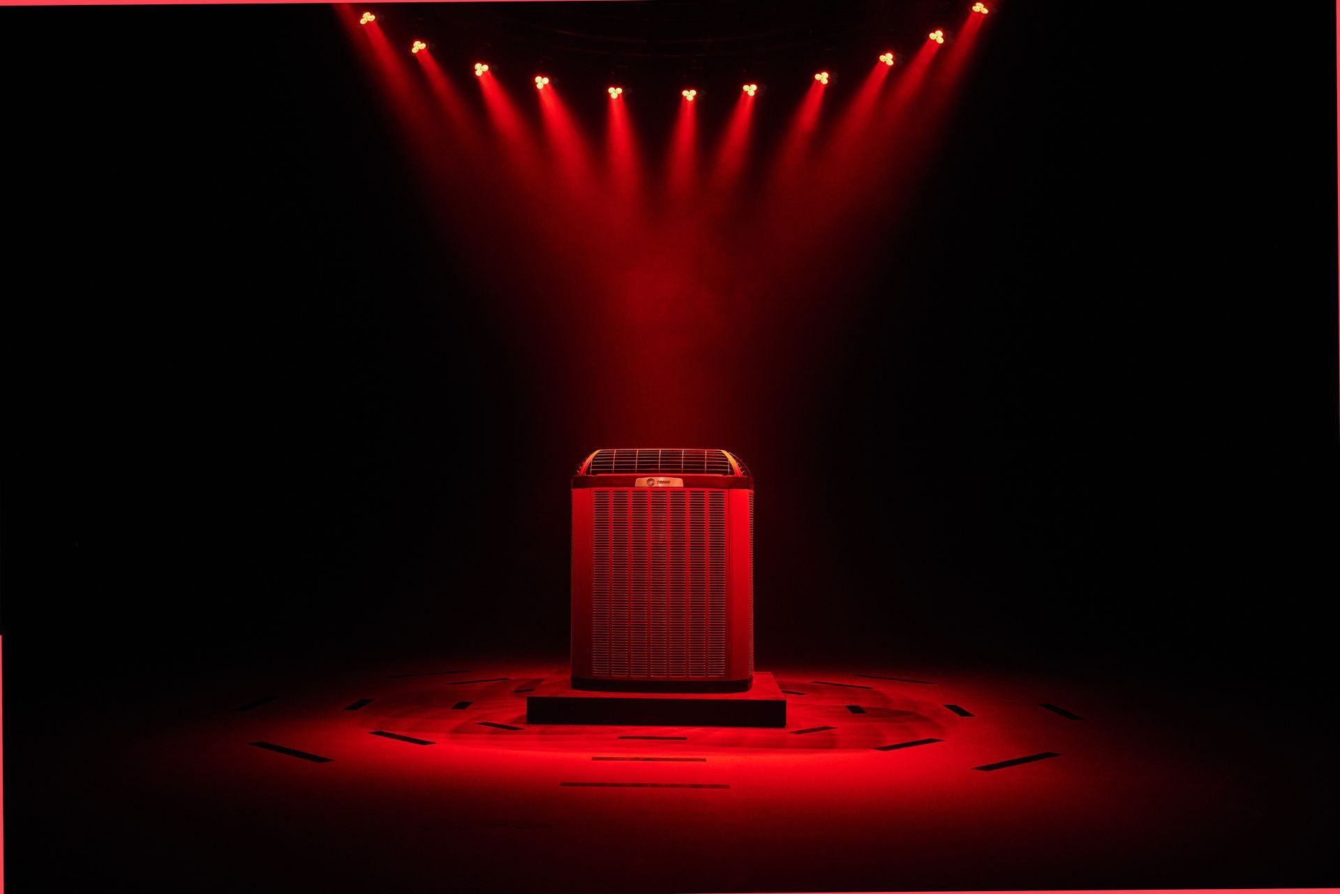 A red box is sitting on a stage with red lights shining on it.