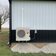 A white air conditioner is mounted on the side of a building.