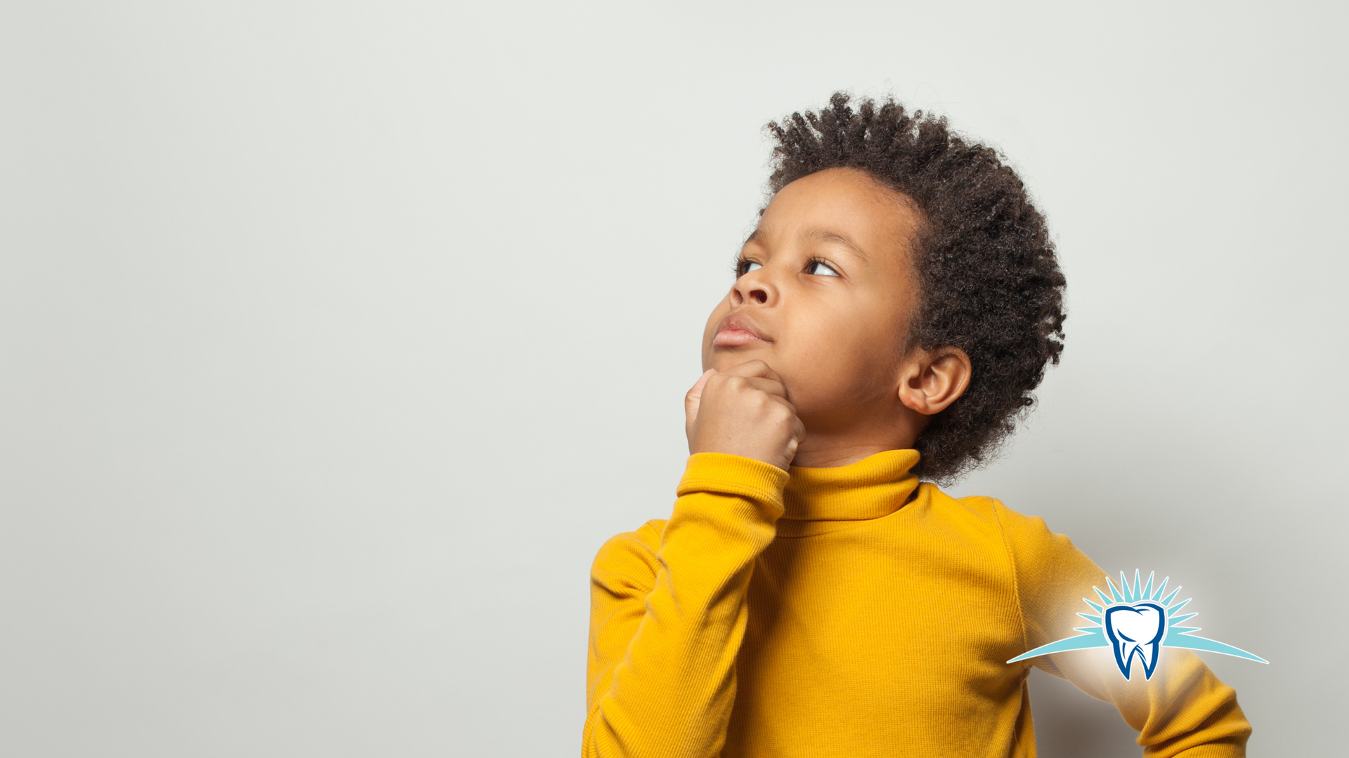Boy in yellow turtleneck, looking up thoughtfully with a hand on his chin.  A tooth graphic is on the right.