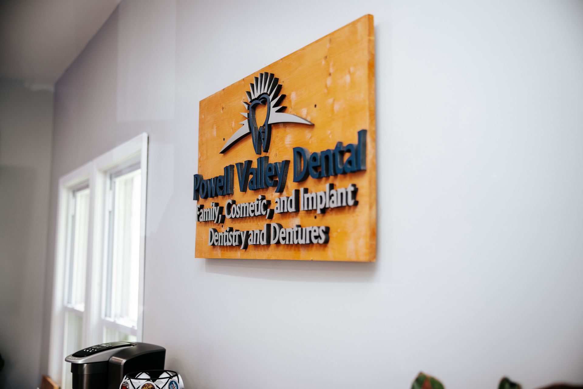 Powell Valley Dental sign on wall, advertising family, cosmetic, implant dentistry, and dentures.