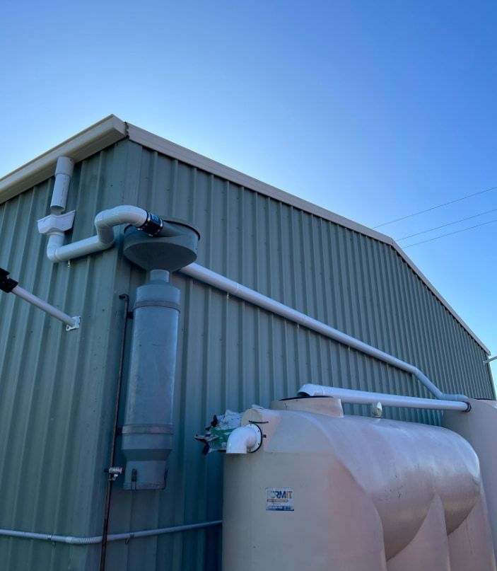 A Large Tank is Attached to the Side of a Building — Plumbtek Solutions In Mudgeeraba, QLD