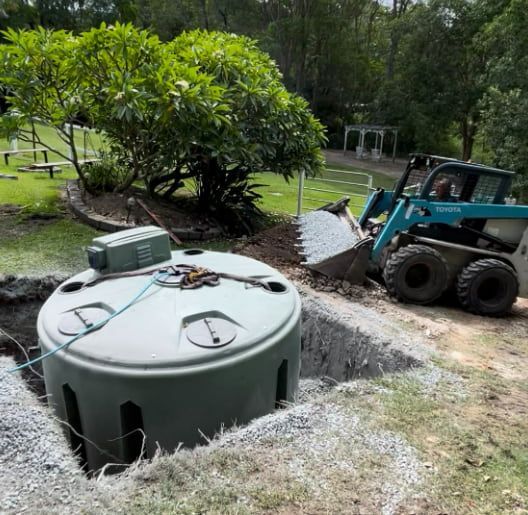 A Bulldozer is Digging a Hole for a Septic Tank — Plumbtek Solutions In Mudgeeraba, QLD