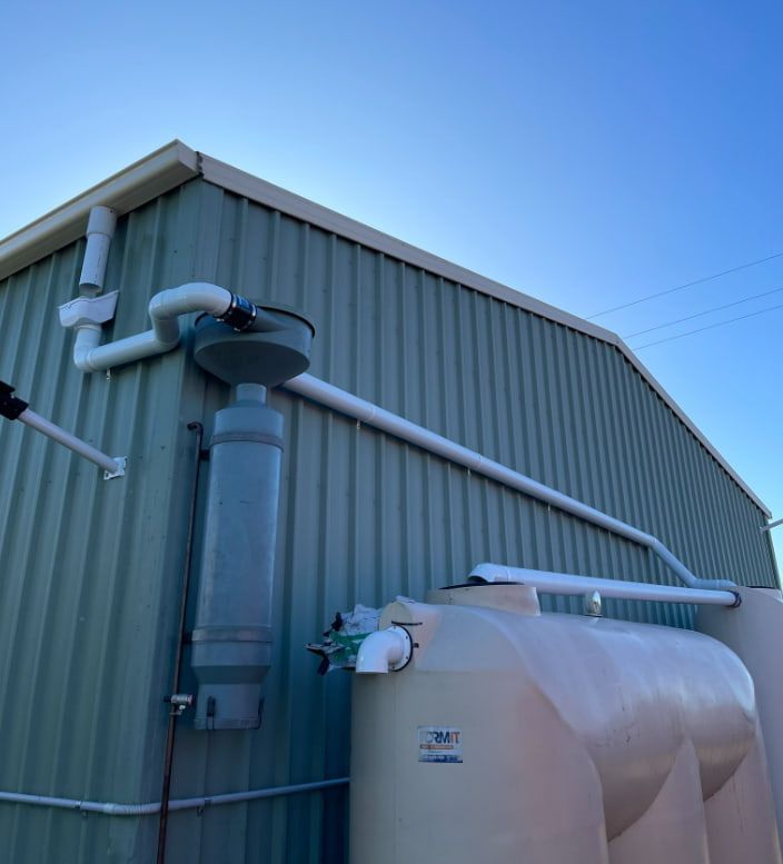 A Building With a Large Tank on the Side of It — Plumbtek Solutions In Mudgeeraba, QLD