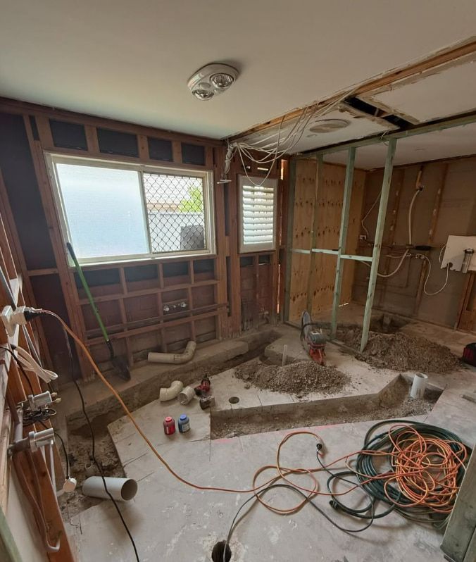 A Room With a Lot of Wires Hanging From the Ceiling and a Window — Plumbtek Solutions In Mudgeeraba, QLD