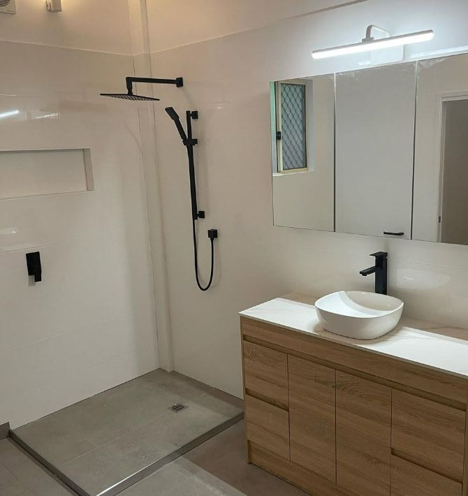 A Bathroom With a Sink, Shower and Mirror — Plumbtek Solutions In Mudgeeraba, QLD