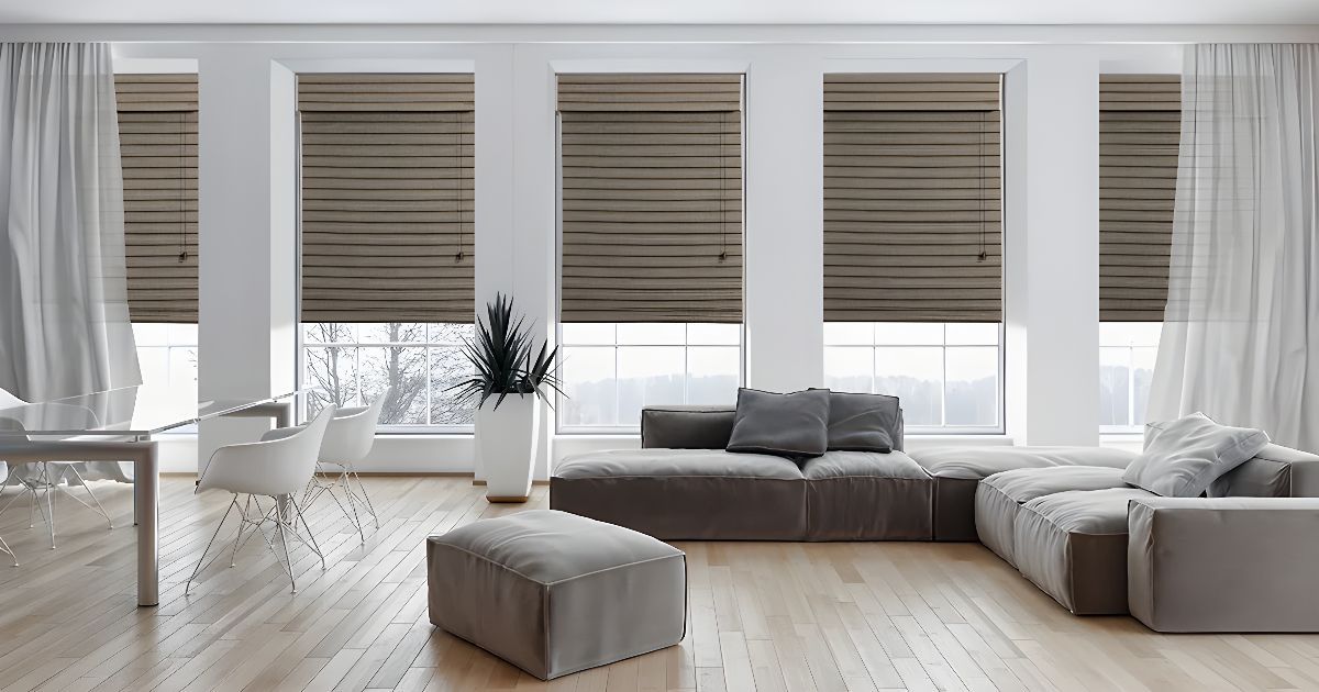 A cozy living room with wooden blinds, a couch, and roman window shades, creating a warm and inviting atmosphere.