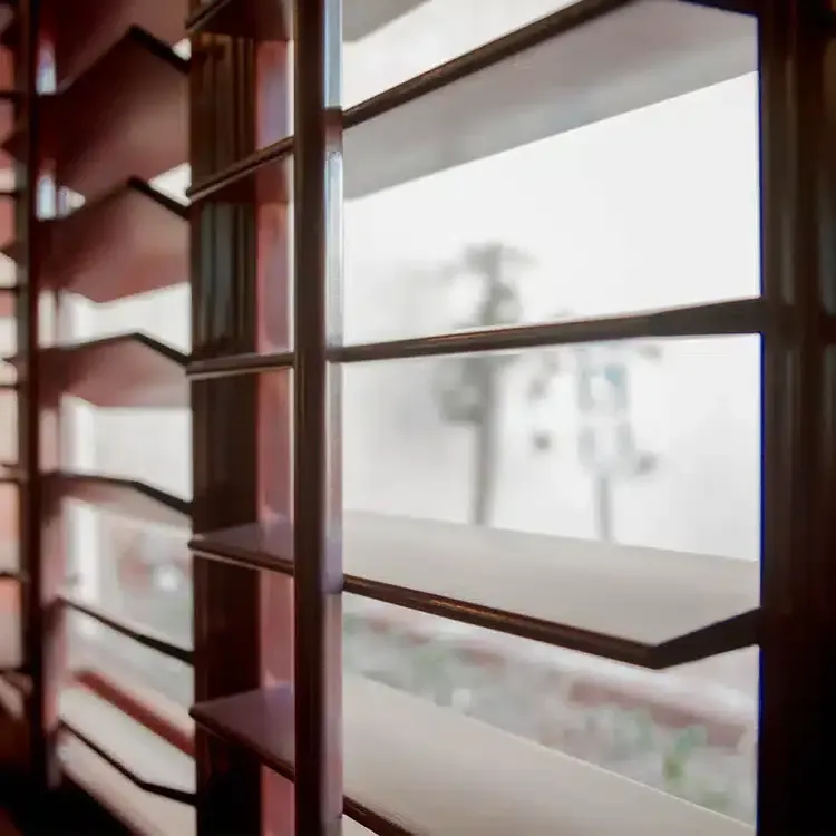 A close up of a window with shutters on it