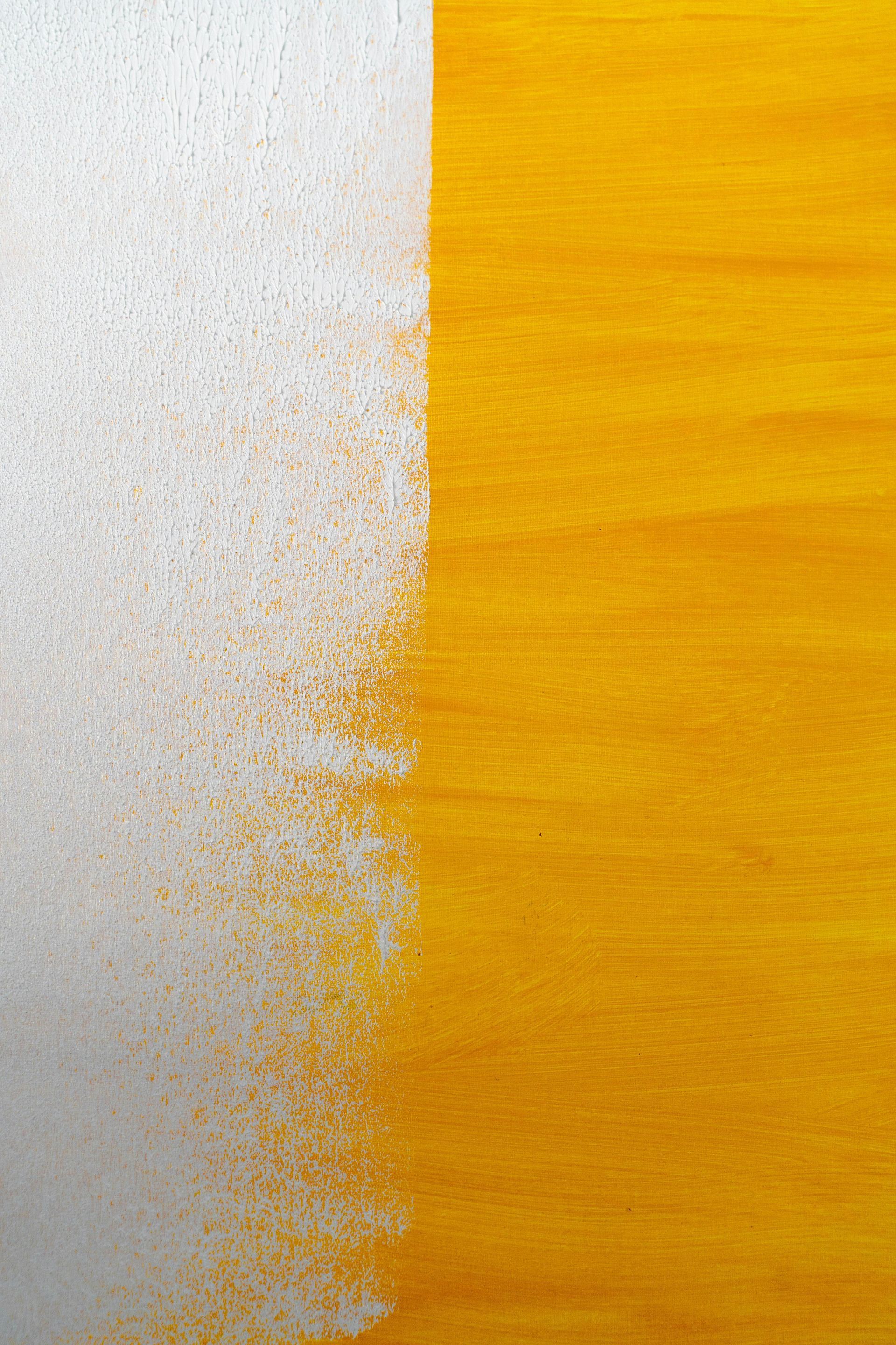 A close up of a yellow and white painting on a wall.