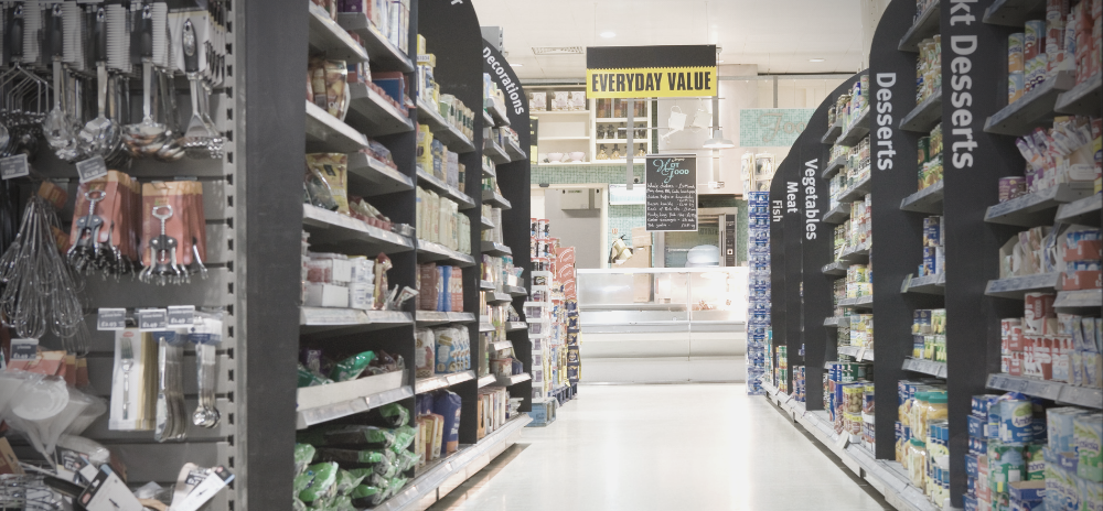 A grocery store aisle filled with lots of food and desserts.