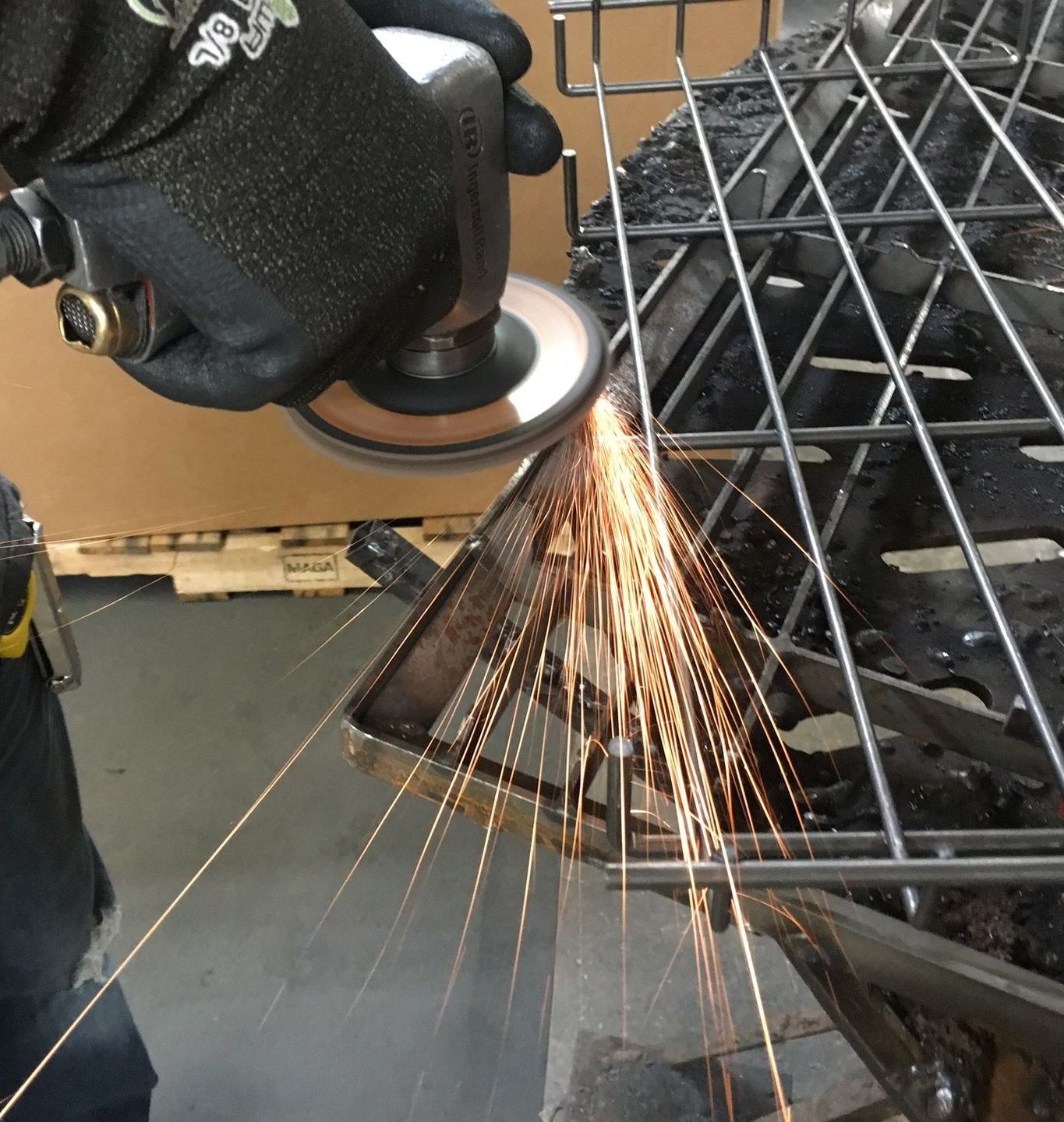 A person is using a grinder to cut a piece of metal
