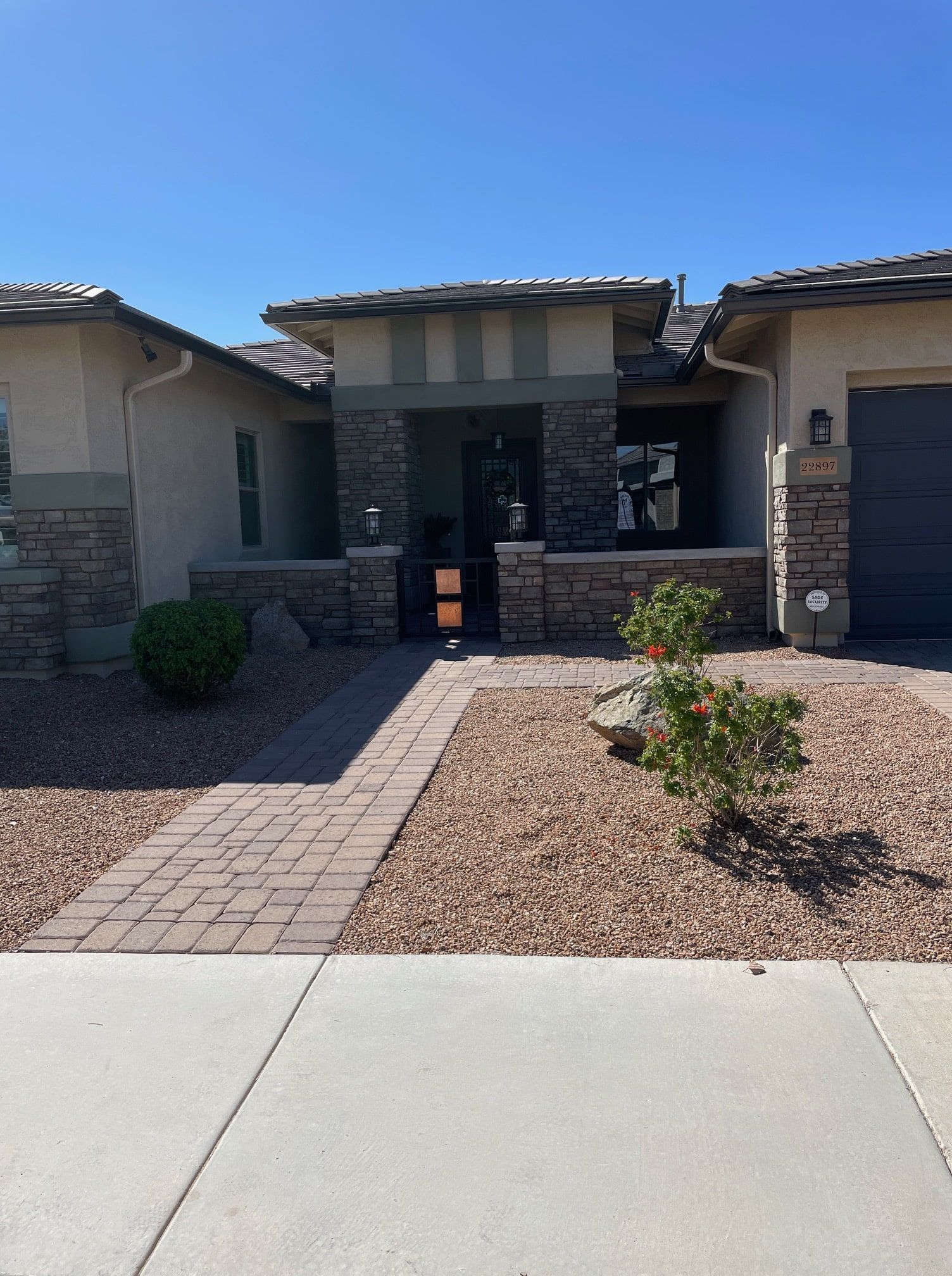 Paver front yard design with stone edging borders and drought tolerant shrubs