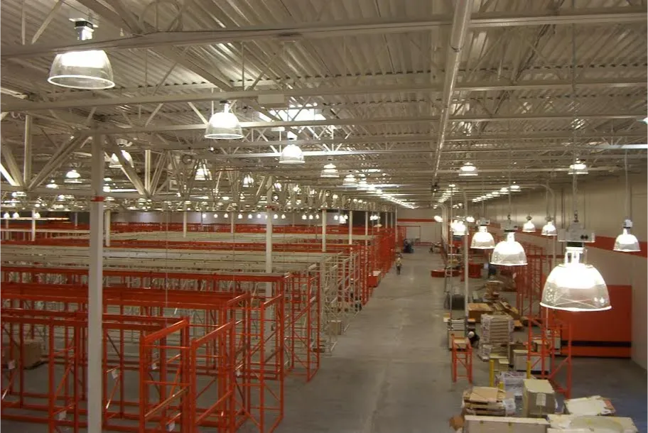 A large warehouse with lots of lights hanging from the ceiling