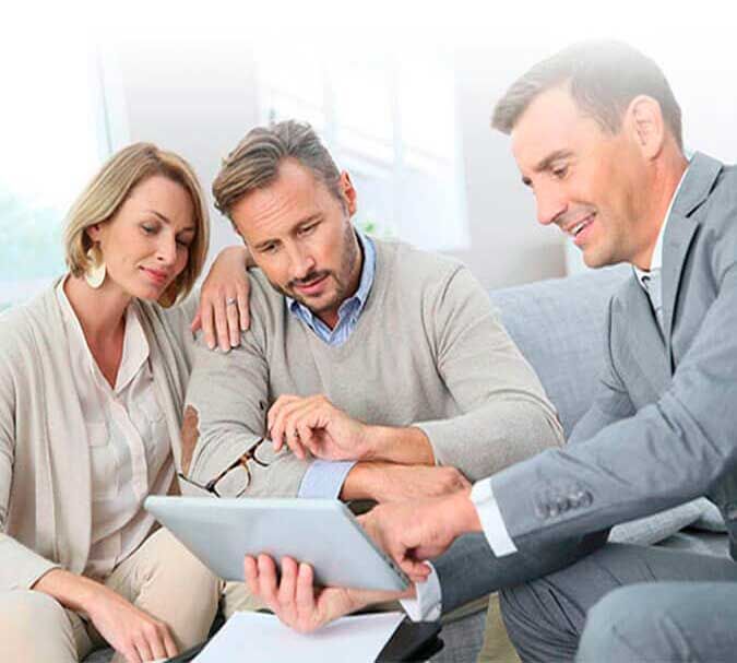 Un grupo de personas está sentada en un sofá mirando una tableta.