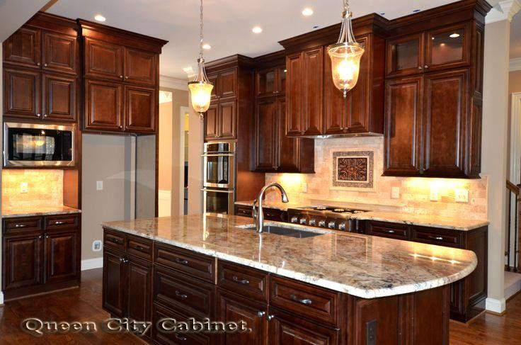 A kitchen with dark wood cabinets and granite counter tops