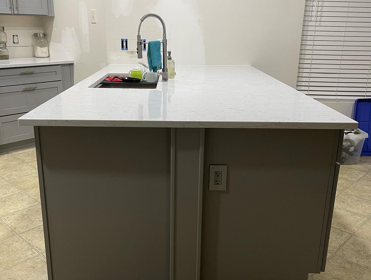A kitchen with a large island and a sink.