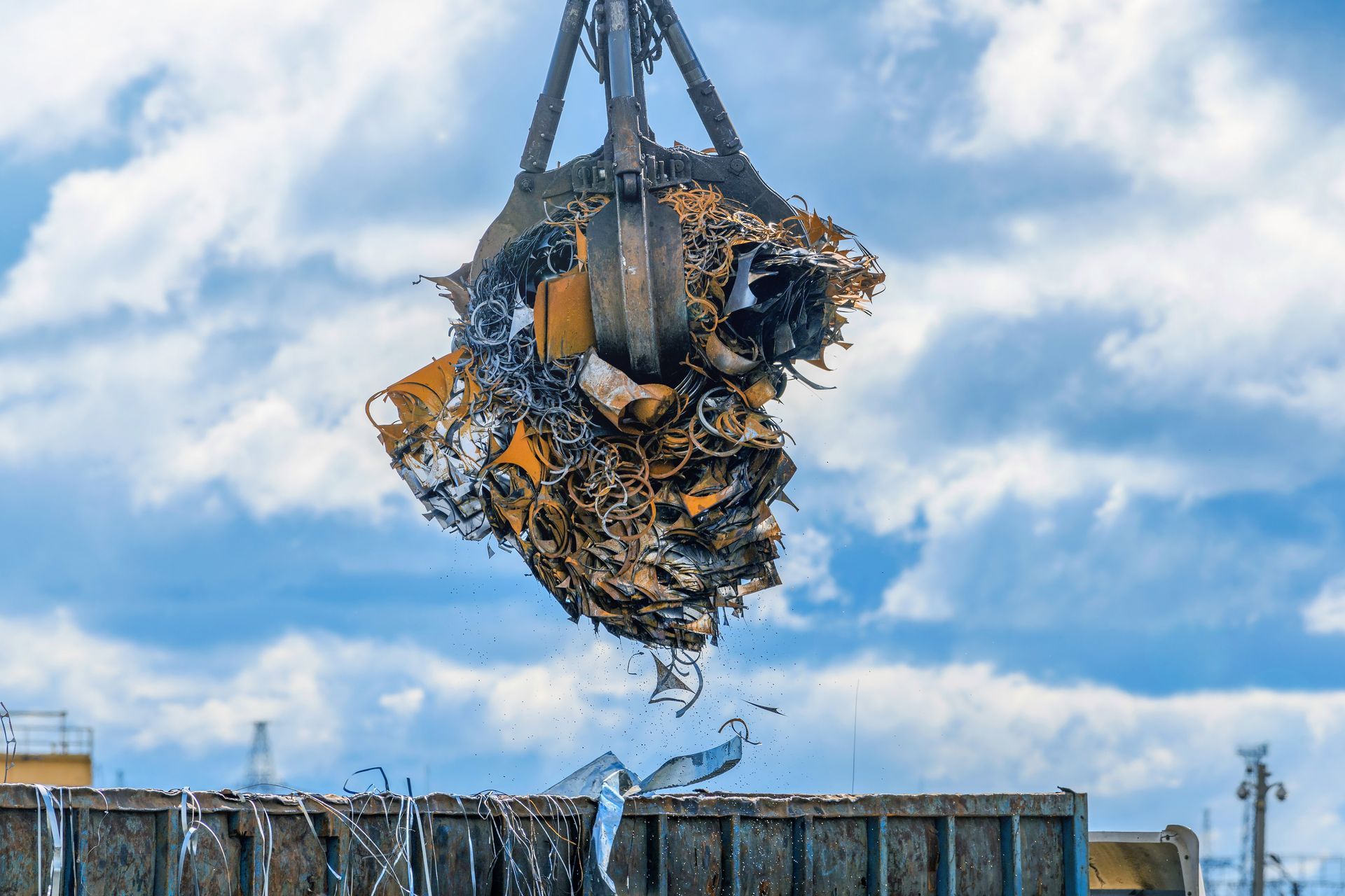 A grab crane loads iron, steel and scrap metal into a truck for recycling. A grab crane loads iron, steel and scrap metal into a truck for recycling.