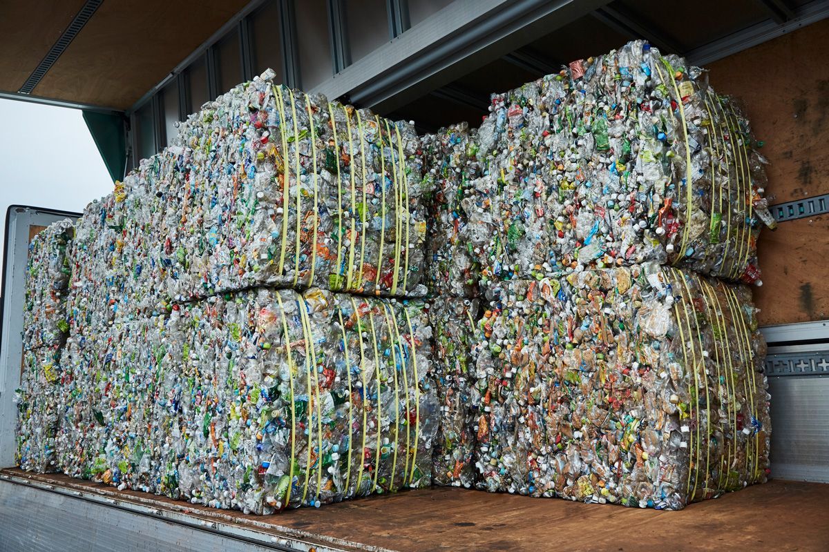 A truck filled with stacks of plastic bottles and cans.