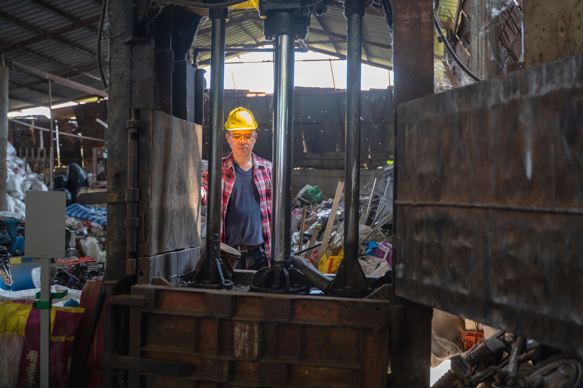 Male staff controls the separation of recyclables at a metal recycling facility.