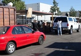 Red Car in a Parking Lot Next to a White Truck — Anaheim, CA — Sunwest Metal, INC