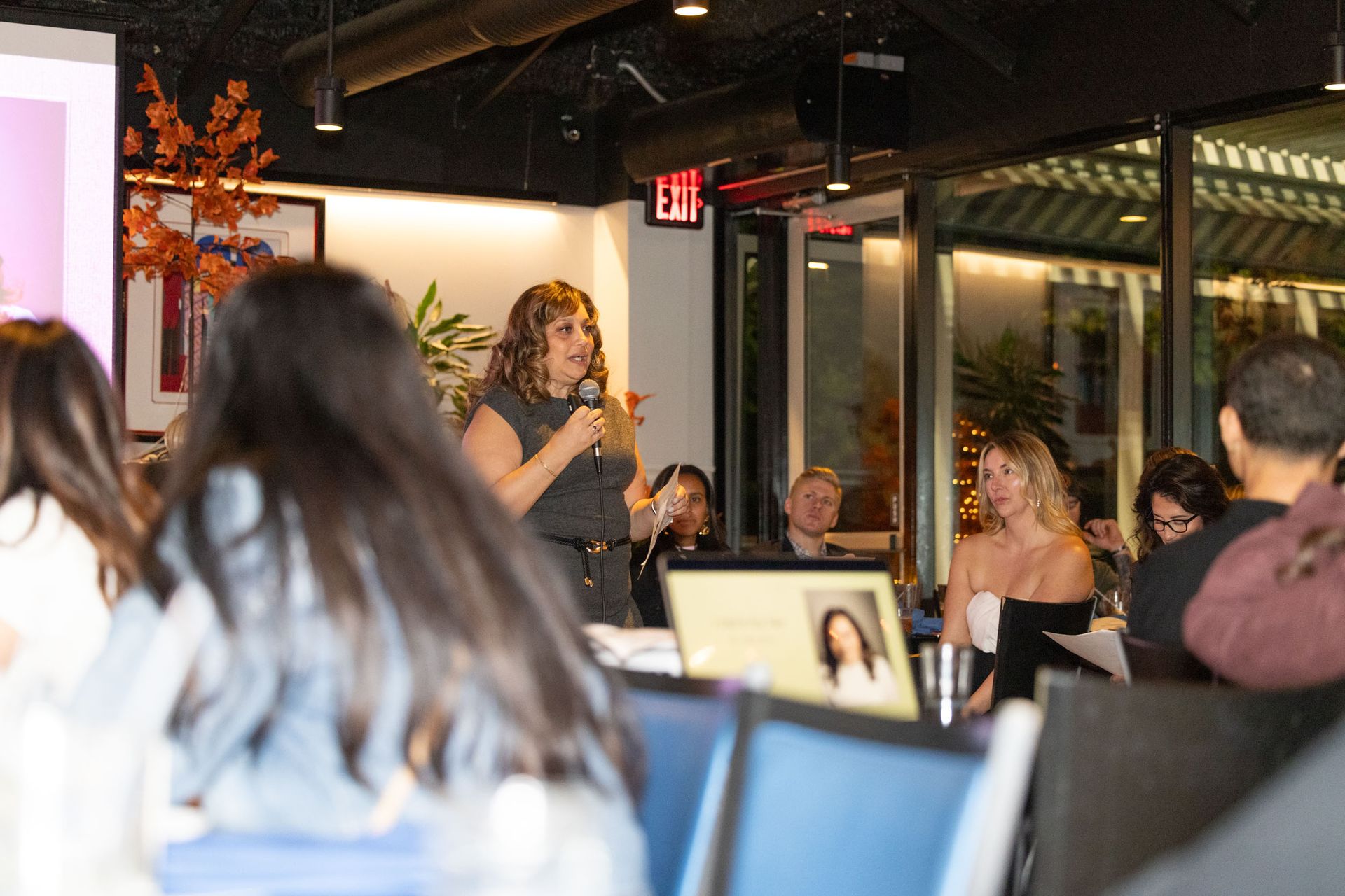 A woman is giving a presentation to a group of people in a room.