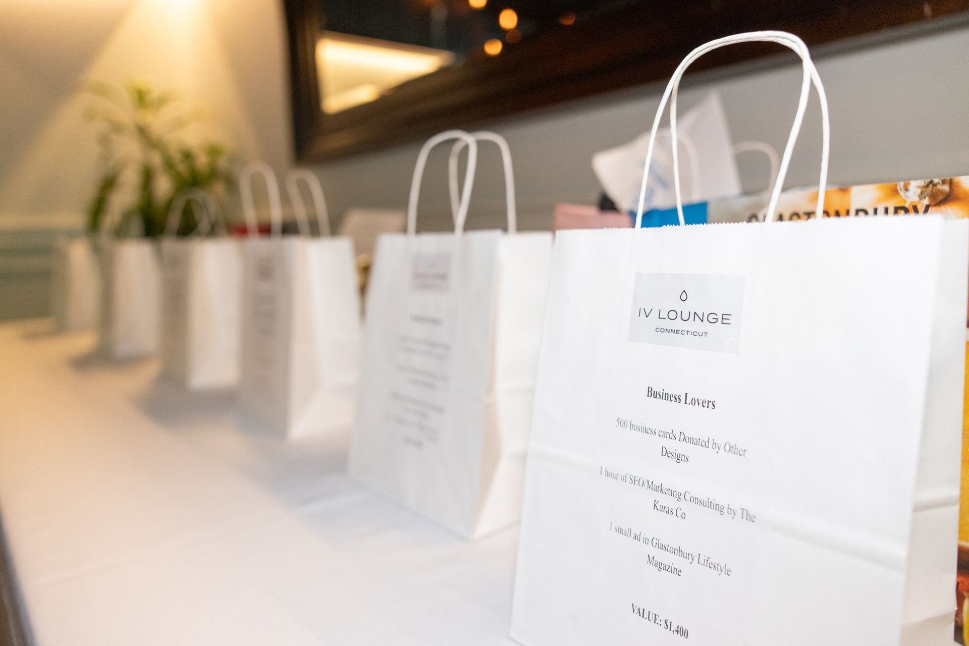 A row of white paper bags are lined up on a table.