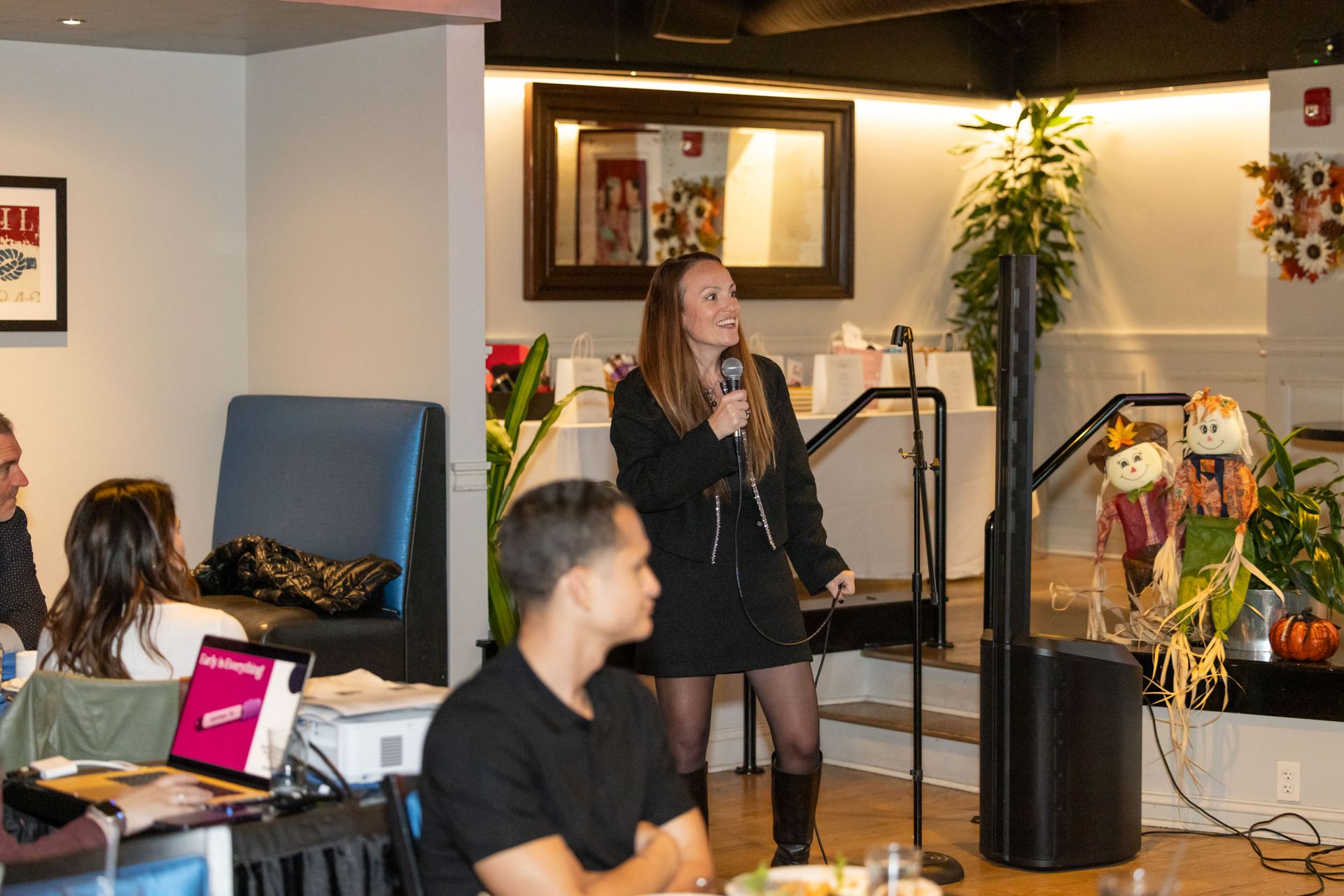 A woman is standing in front of a microphone in a room.