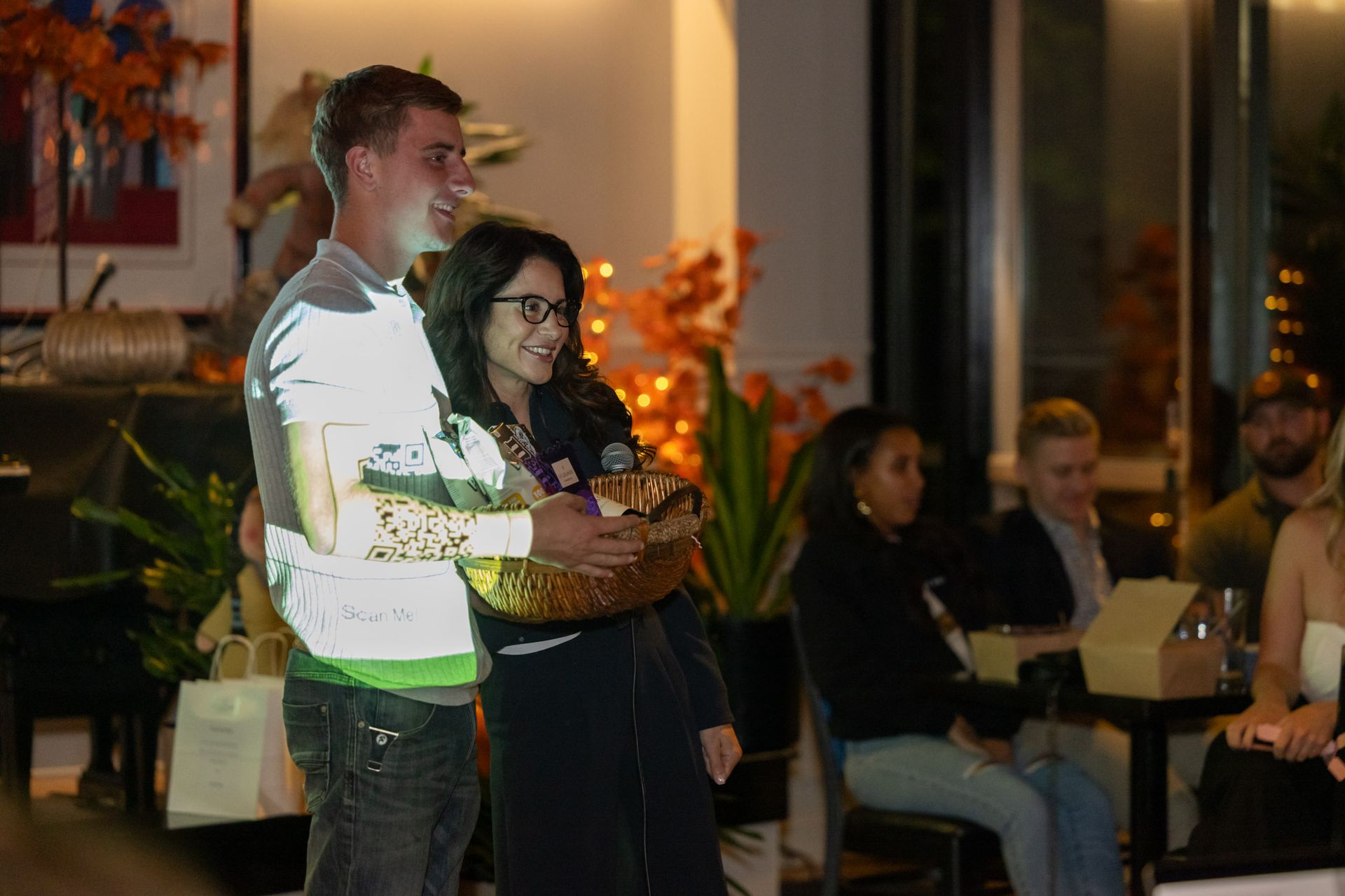 A man and a woman are standing next to each other in a room holding a basket.