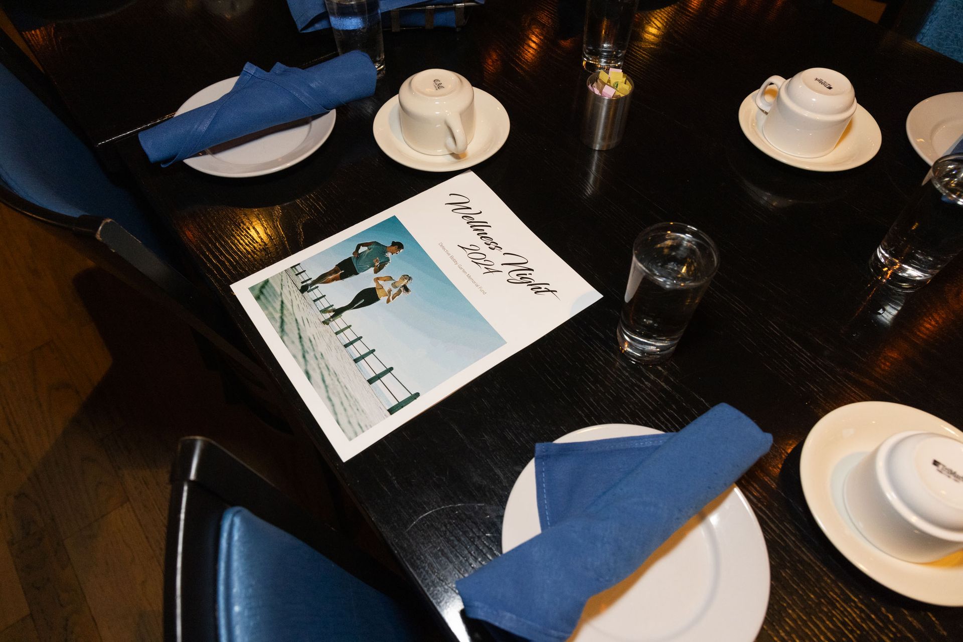 A table with plates cups and a menu on it