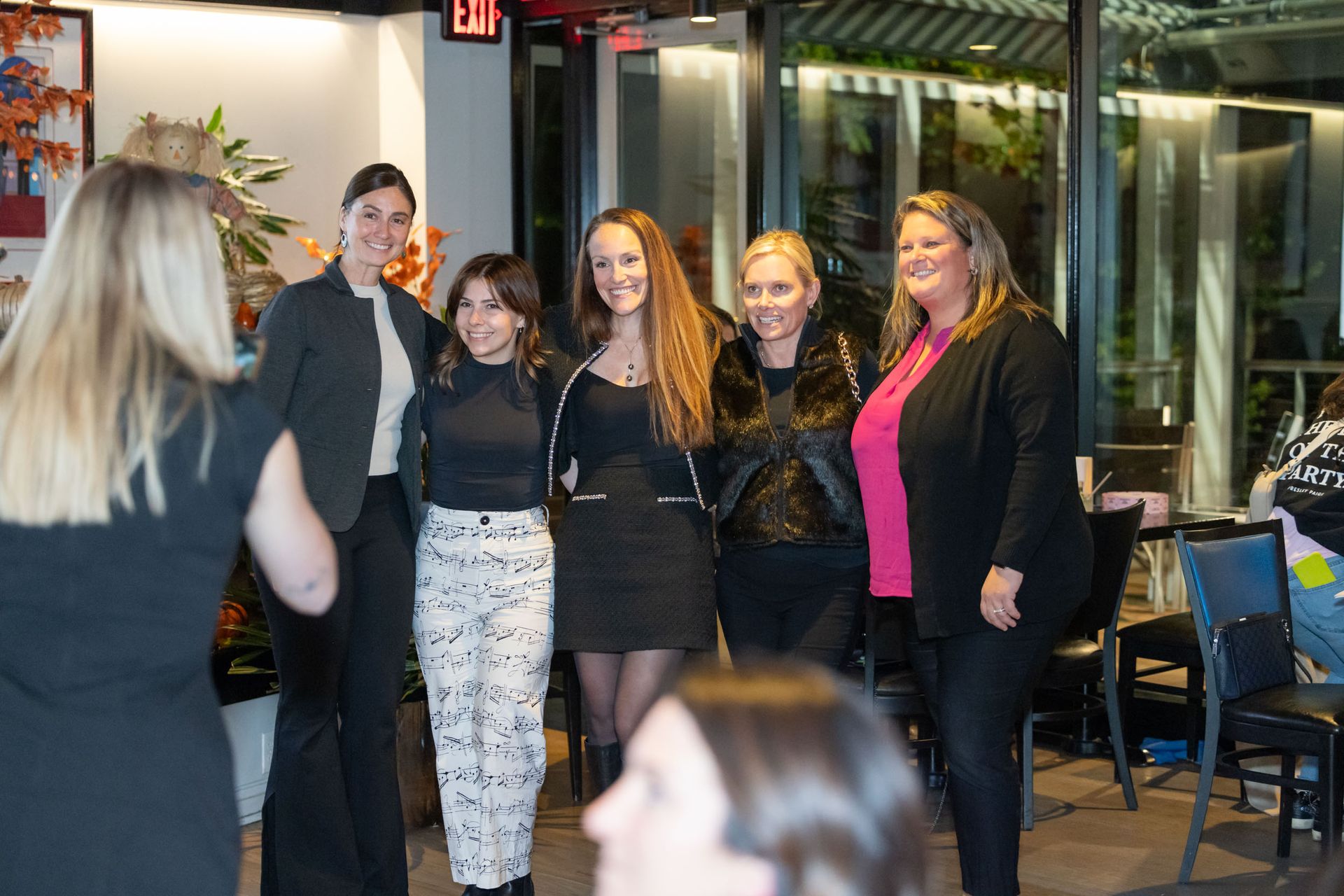 A group of women are posing for a picture in a restaurant.