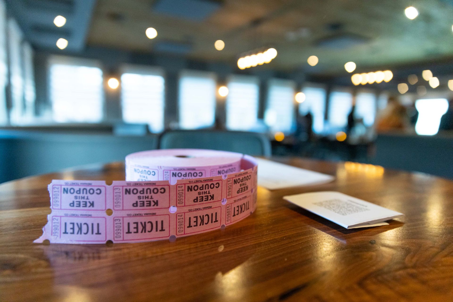 A roll of tickets is sitting on a wooden table.