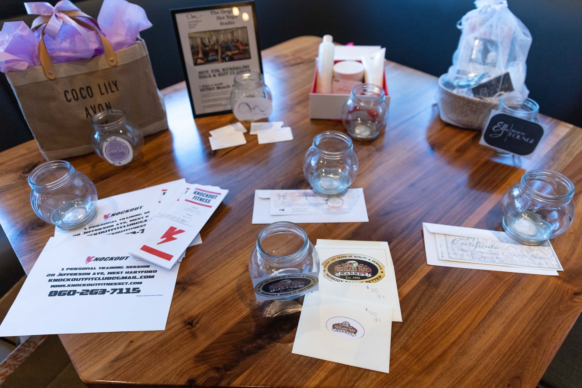 A wooden table with a lot of jars and papers on it.