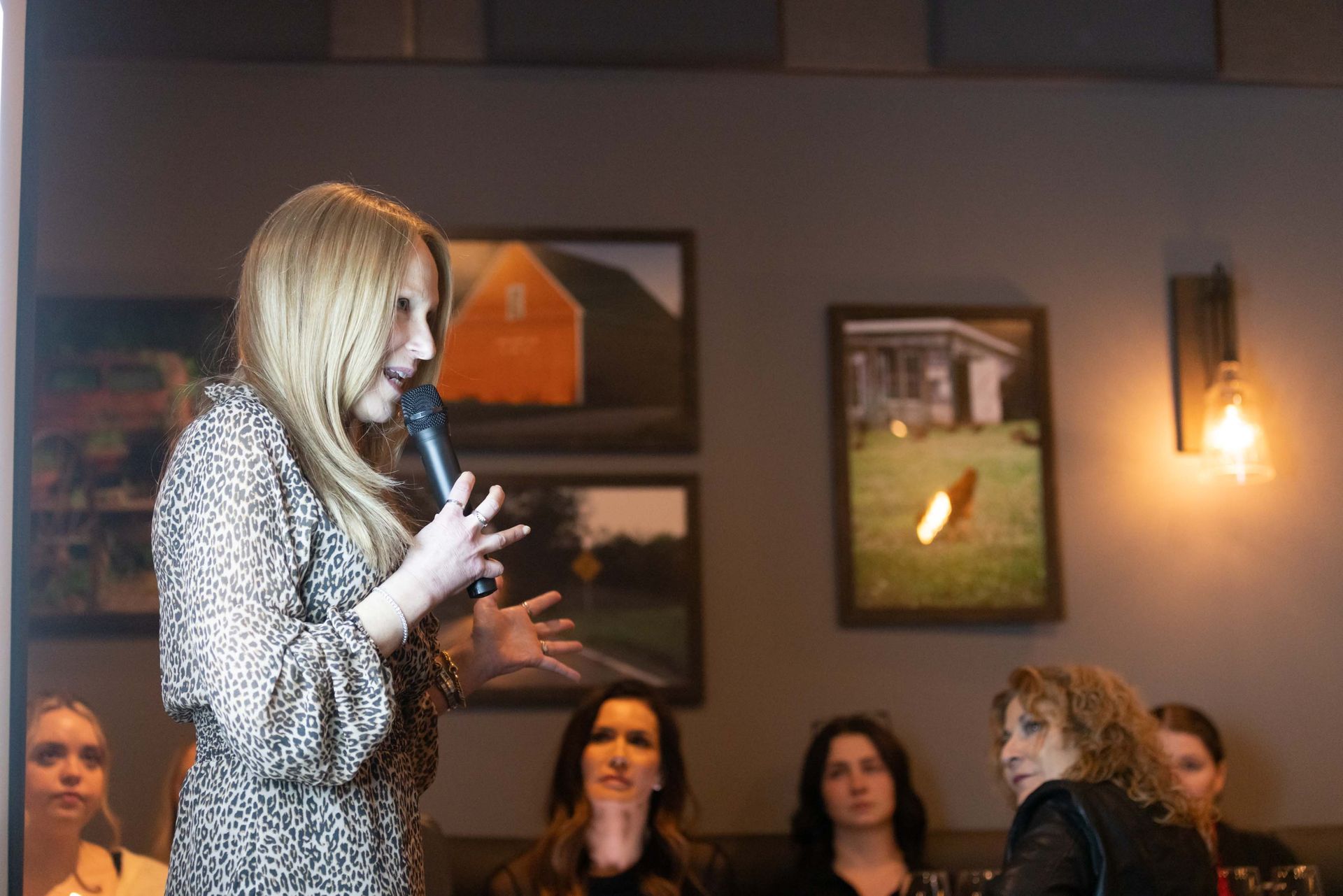 A woman is holding a microphone in front of a group of people.