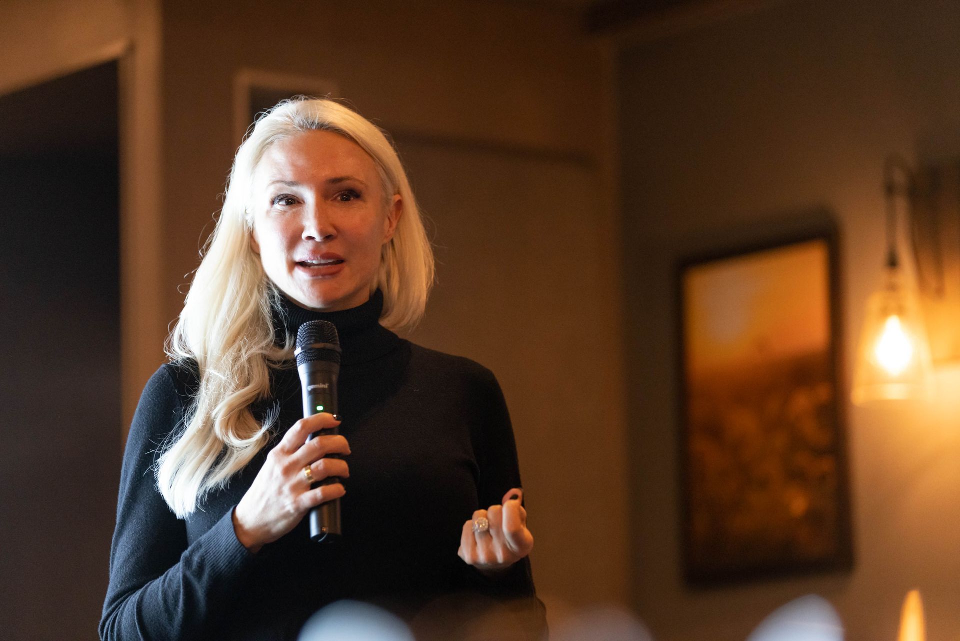 A woman is holding a microphone and speaking into it.