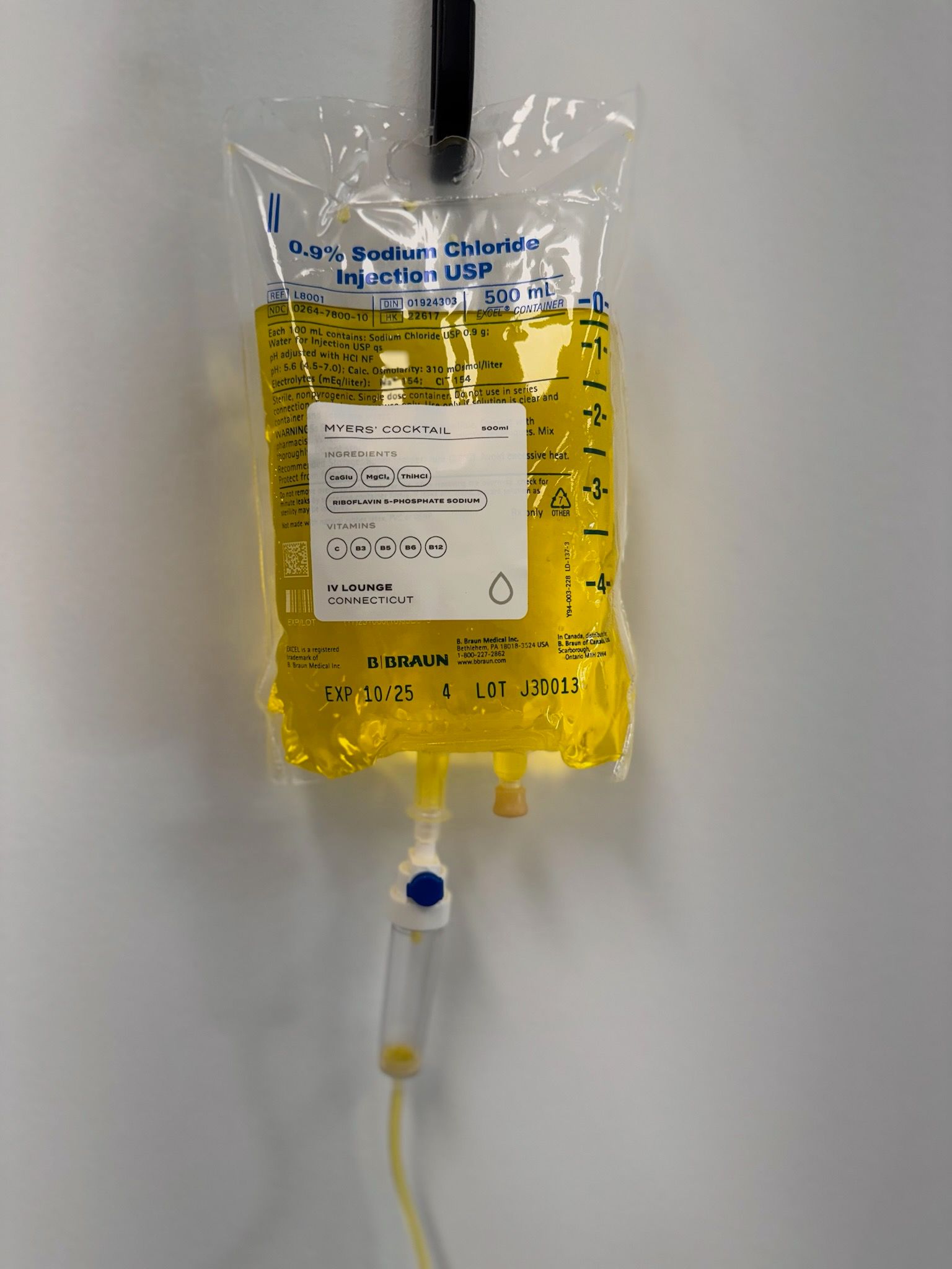 Yellow IV bag for proactive wellness hanging, connected to tubing with a flow regulator