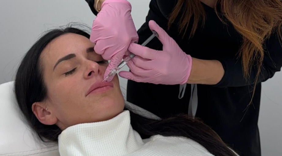 A nurse applying lip filler injection