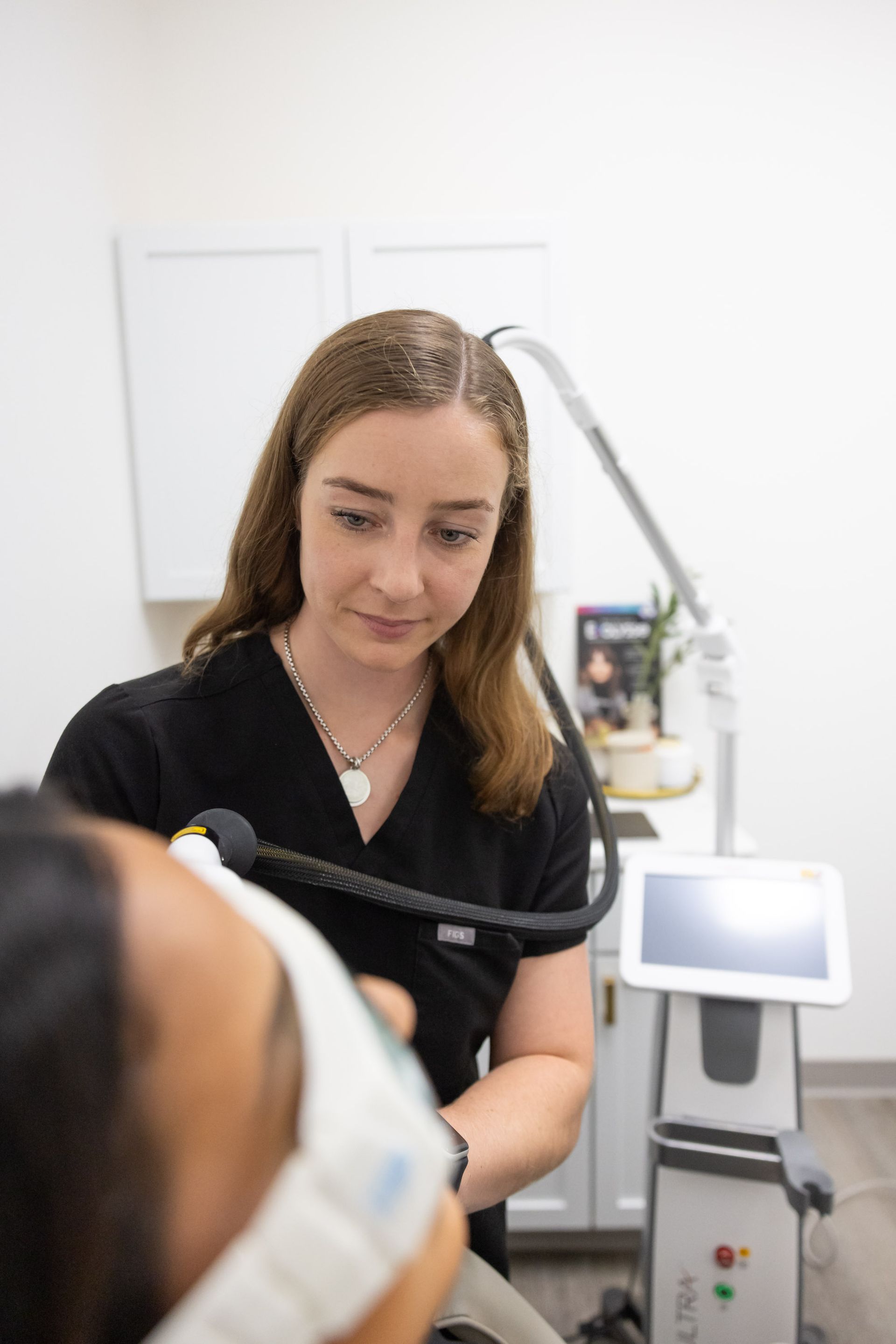 A woman is getting a laser treatment on her face.