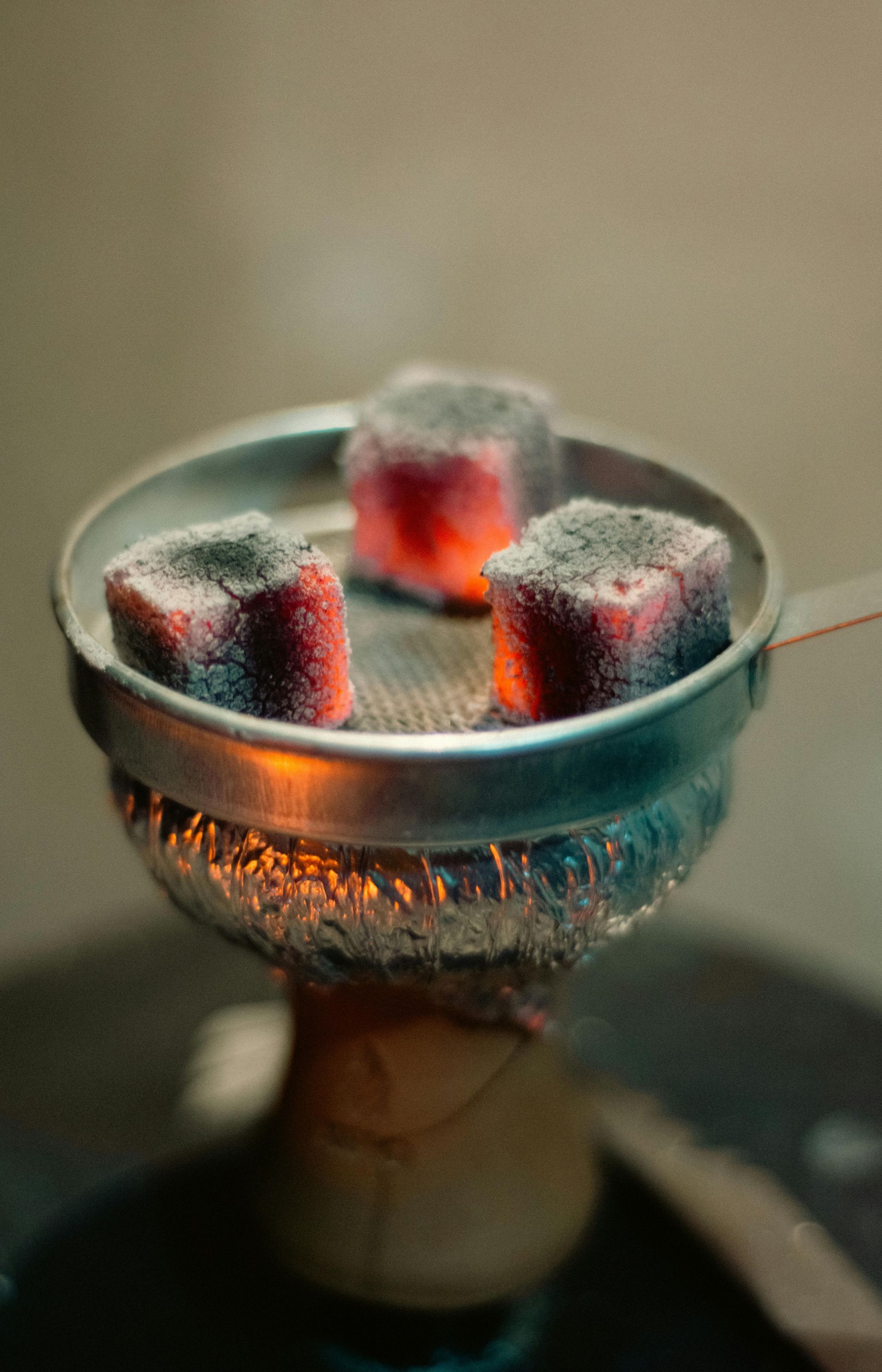 A close up of a bowl of charcoal on a hookah.