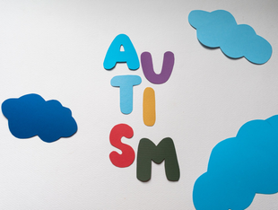 Colorful foam letters spelling “AUSUM” with blue clouds on a light background
