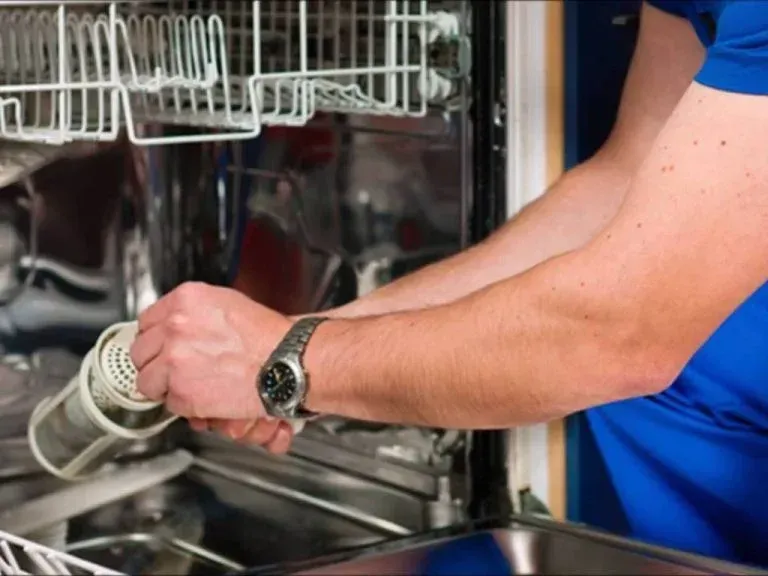 Person loading a dishwasher, holding a spray nozzle under the open rack