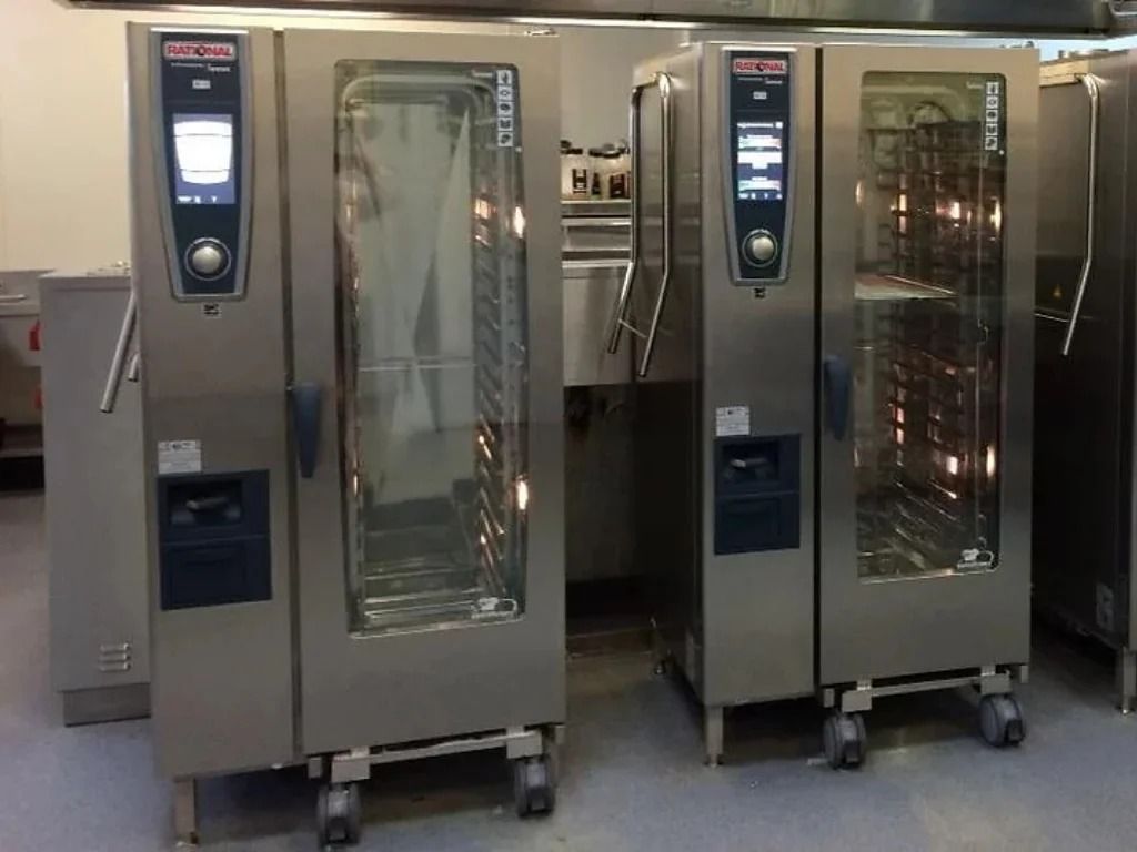 Two stainless steel commercial ovens with glass doors in a kitchen or bakery setting