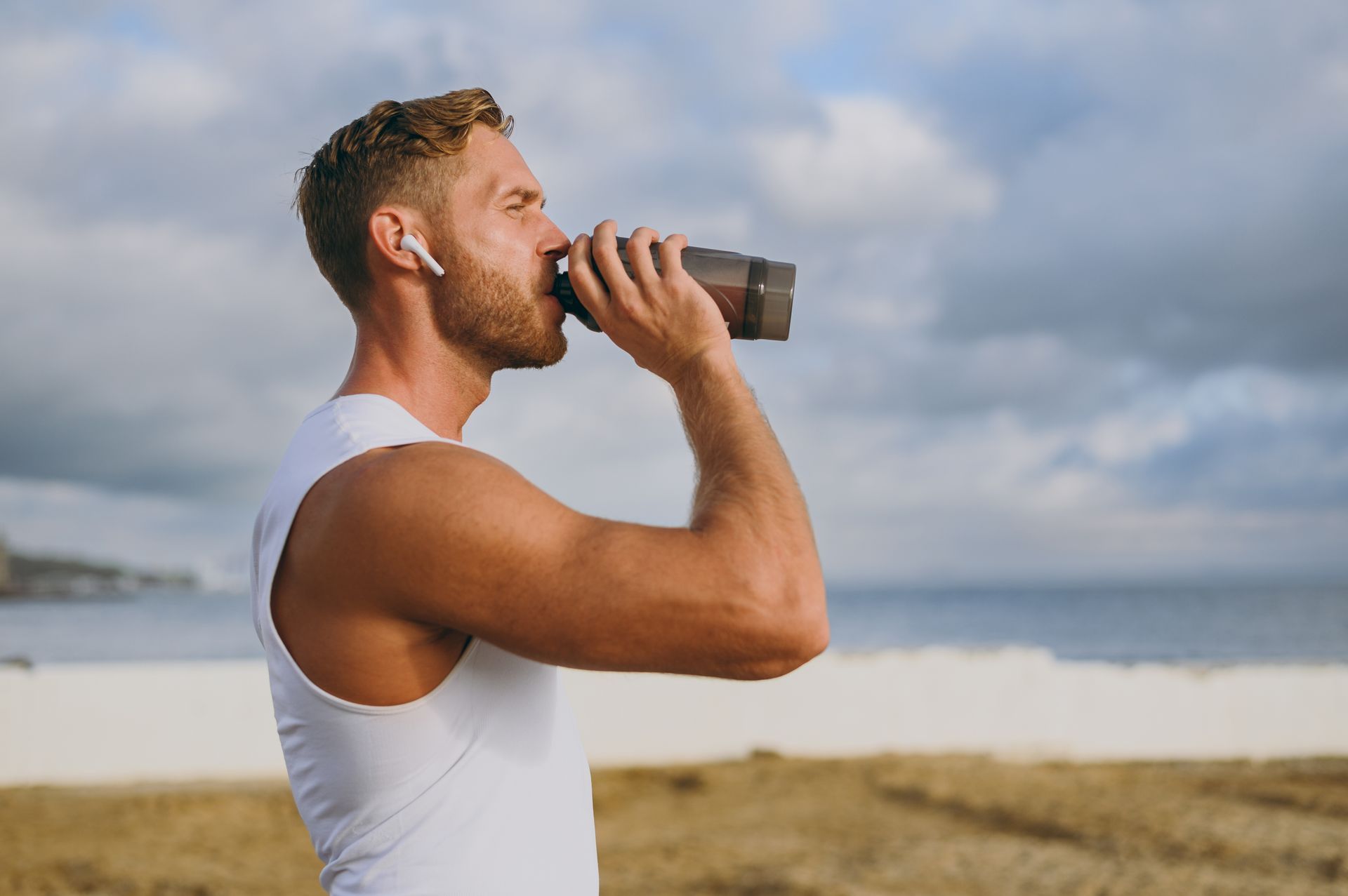 Man at the beach drinking water