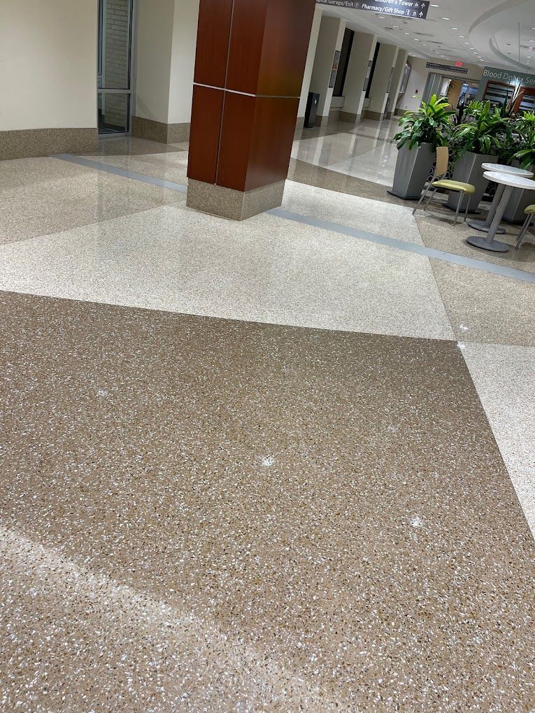 A hallway with a marble floor and a wooden pillar.